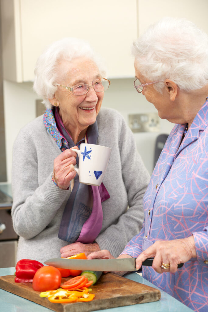 deux femmes seniors qui boivent le thé et cuisinent, bien vieillir à domicile